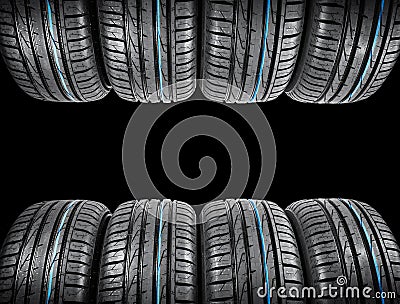 Studio shot of a set of summer car tires on black background. Tire stack background. Car tyre protector close up. Black rubber tir Stock Photo