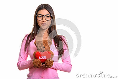 Studio shot of young beautiful Brazilian nerd woman holding tedd Stock Photo