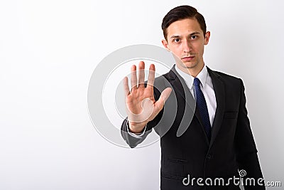 Studio shot of young handsome businessman showing stop hand sign Stock Photo