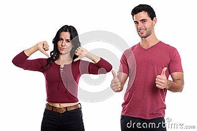 Studio shot of young happy couple smiling with man giving thumbs Stock Photo