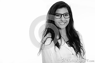 Studio shot of young happy Persian woman smiling with eyeglasses Stock Photo