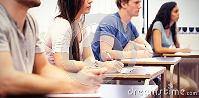 Studious young adults listening in classroom Stock Photo