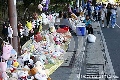 Stuffed animal toys are displayed for sale along a sidewalk Editorial Stock Photo