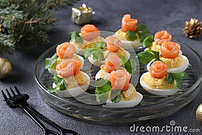 Stuffed eggs with salted salmon and cheese, a delicious festive snack on a dark background. Closeup Stock Photo