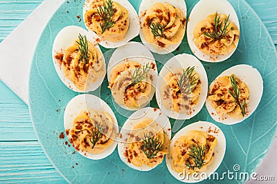 Stuffed eggs with smoked paprika on blue plate for easter table Stock Photo