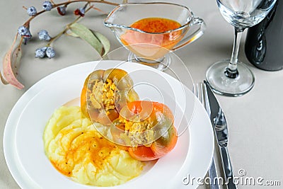 Stuffed with meat and vegetables and spices bell pepper on the white dish on the festive decorated table Stock Photo