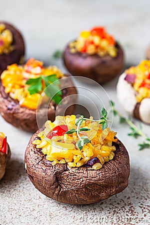 Stuffed portobello mushrooms with bulgur, vegetables and aromatic herbs on concrete background. Vegetarian food. Close up Stock Photo