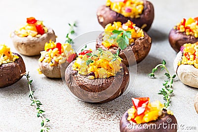 Stuffed portobello mushrooms with bulgur, vegetables and aromatic herbs on concrete background. Vegetarian food Stock Photo