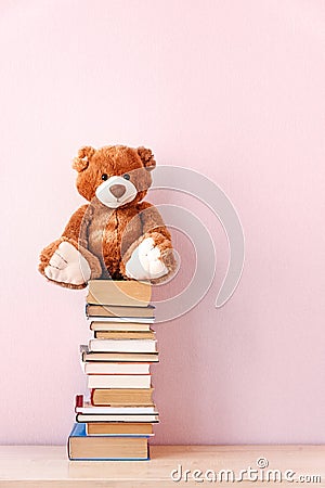 Stuffed toy Teddy bear with glasses, a stack of books and a stopwatch. Education concept, back to school, reading speed Stock Photo