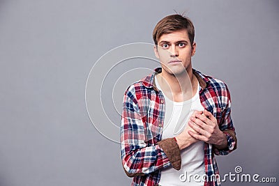 Stunned dazed man in checkered shirt with hand on chest Stock Photo