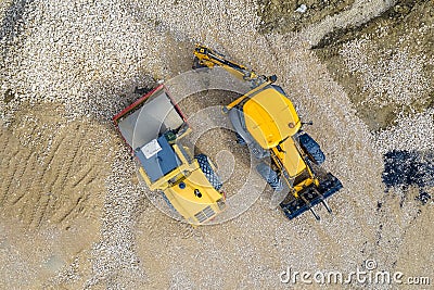 The stopped yellow excavator and drum roller at a construction site Stock Photo