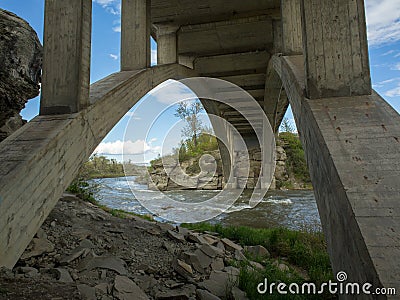 Stunning arched concrete bridge crossing a crystal clear trout stream in Alberta Stock Photo