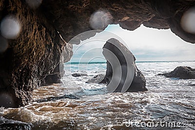 Stunning archway formed by a rock formation situated on a body of water Stock Photo