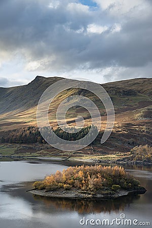 Stunning Autumn Fall landscape of Hawes Water with epic lighting and dramatic sunlight in Lake District Stock Photo