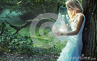 Stunning blond lady holding huge lightbulb Stock Photo