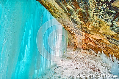 Stunning blue sheet of ice covering entrance to cavern in winter Stock Photo