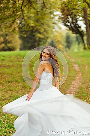 Stunning bride looks over her shoulder while whirling Stock Photo