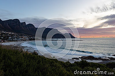 Stunning camps bay with houses on the beach, with dramatic mountains at sunset Stock Photo