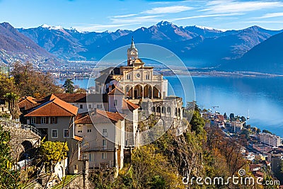 Stunning close up panorama view of Madonna del Sasso church above Locarno city with Lake Maggiore, snow covered Swiss Alps Stock Photo