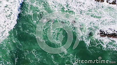 Stunning foamy sea water splashing on seashore stones. Aerial stormy blue waves Stock Photo