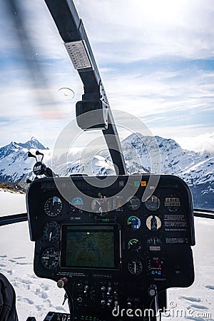 Stunning helicopter cockpit image with snowy Mount Aspiring in the background on a sunny winter day, New Zealand Editorial Stock Photo