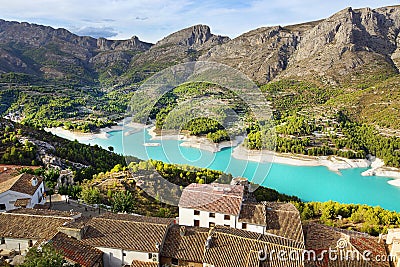 A stunning lake in Spain with a gentle blue water hid between mountains with small towns Stock Photo