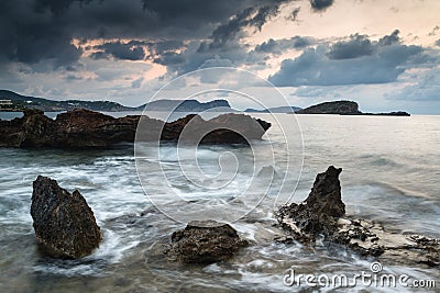 Stunning landscape dawn sunrise with rocky coastline and long ex Stock Photo