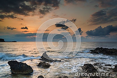 Stunning landscape dawn sunrise with rocky coastline and long ex Stock Photo