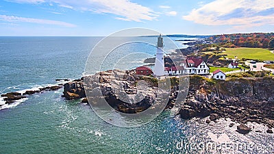 Stunning lighthouse on rocky cliffs in Maine from aerial view Stock Photo