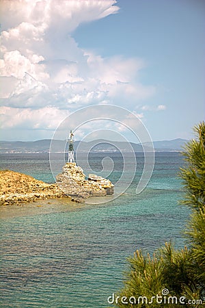 Stunning lighthouse situated atop a rocky outcrop jutting out into the sparkling blue waters Stock Photo