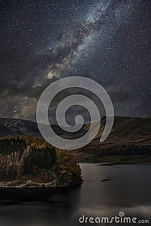 Stunning majestic digital composite landscape of Milky Way over Hawes Water in Lake District Stock Photo