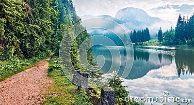 Stunning morning view of Lacu Rosu lake. Misty summer scene of Harghita County, Romania, Europe. Beauty of nature concept backgrou Stock Photo