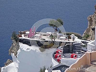 Stunning outdoor seating at the terrace over the caldera on vibrant blue Aegean sea, Santorini island Stock Photo