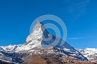 Stunning panorama view of the famous Matterhorn peak of Swiss Alps on sunny autumn day with snow and blue sky, from the train Stock Photo