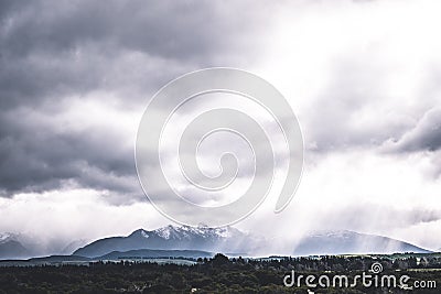 Stunning scene landscape during a cloudy day with sun ray through the cloud over the snow mountain. Dramatic photo style. I Stock Photo