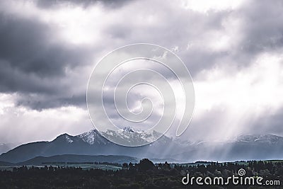 Stunning scene landscape during a cloudy day with sun ray through the cloud over the snow mountain. Dramatic photo style. I Stock Photo