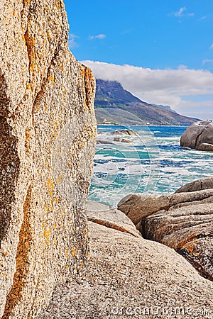 Stunning seaside location for a summer holiday in Cape Town. Boulders at a beach with ocean waves and water washing over Stock Photo