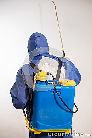 Stunning shot of a professional exterminator spraying a chemical over a white wall Stock Photo