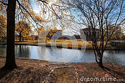 A stunning shot of the still blue lake water surrounded by gorgeous autumn trees in the park with a view of The Parthenon Stock Photo