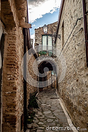 Rocca Imperiale: Italian Street with Old Houses, Stone Floors, and the street continues to a gate under the house Stock Photo