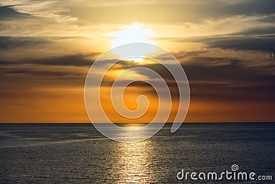 Stunning sunset in a dramatic sky above a serene ocean Stock Photo