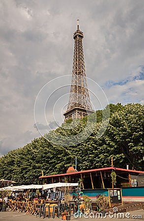 Stunning view of the iconic Eiffel Tower in Paris, France, with a quaint cafe in the foreground Editorial Stock Photo