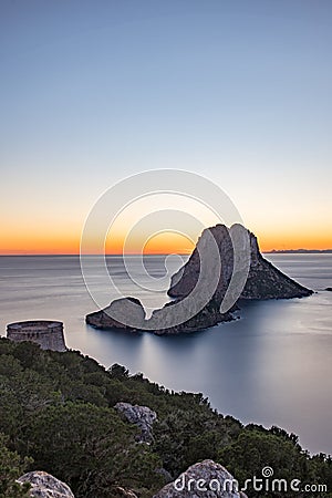 Stunning views of the sun falling behind Es Vedra with the Torre del Savinar in Es Vedra, Sant Josep de Sa Talaia, Ibiza, Spain. Stock Photo