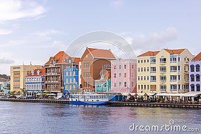 Stunning vista of vibrant houses in the heart of Willemstad, overlooking St. Anna Bay with backdrop of cloudy sky. Editorial Stock Photo