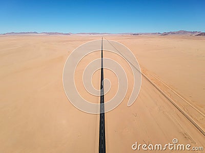 Stunning wide angle aerial drone view of the B4 desert road and a train line between LÃ¼deritz and Keetmanshoop Stock Photo