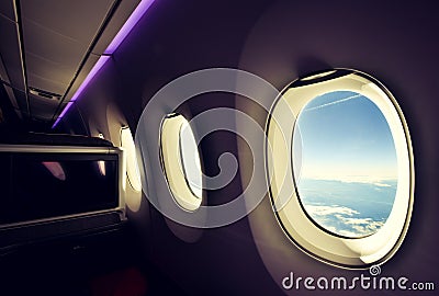 Stunning wide angle view of three airplane windows seen from a business class seat on a long haul widebody aircraft Stock Photo