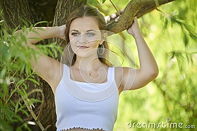 Stuning young fashion model poses near willow tree Stock Photo