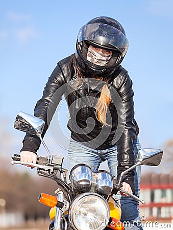 Stunt rider standing on motorcycle while making trick, balancing Stock Photo
