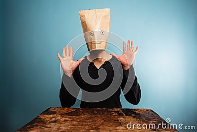 Stupid man with bag over his head and hands up Stock Photo
