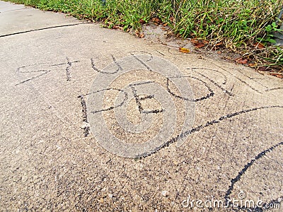 Stupid people carved into side walk Stock Photo